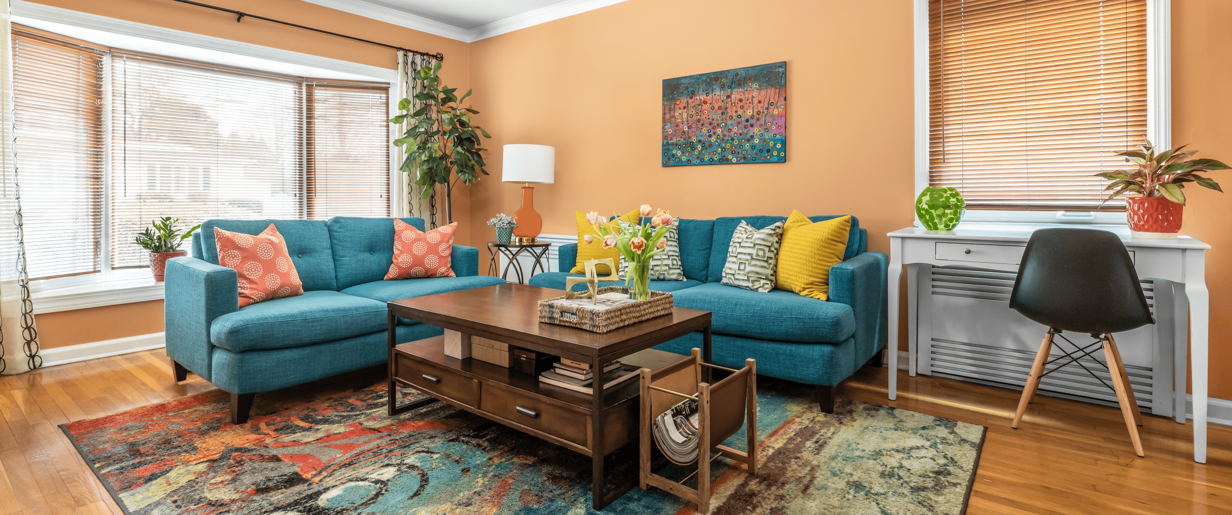 Living Room with orange walls, wooden floors, and blue-green couch